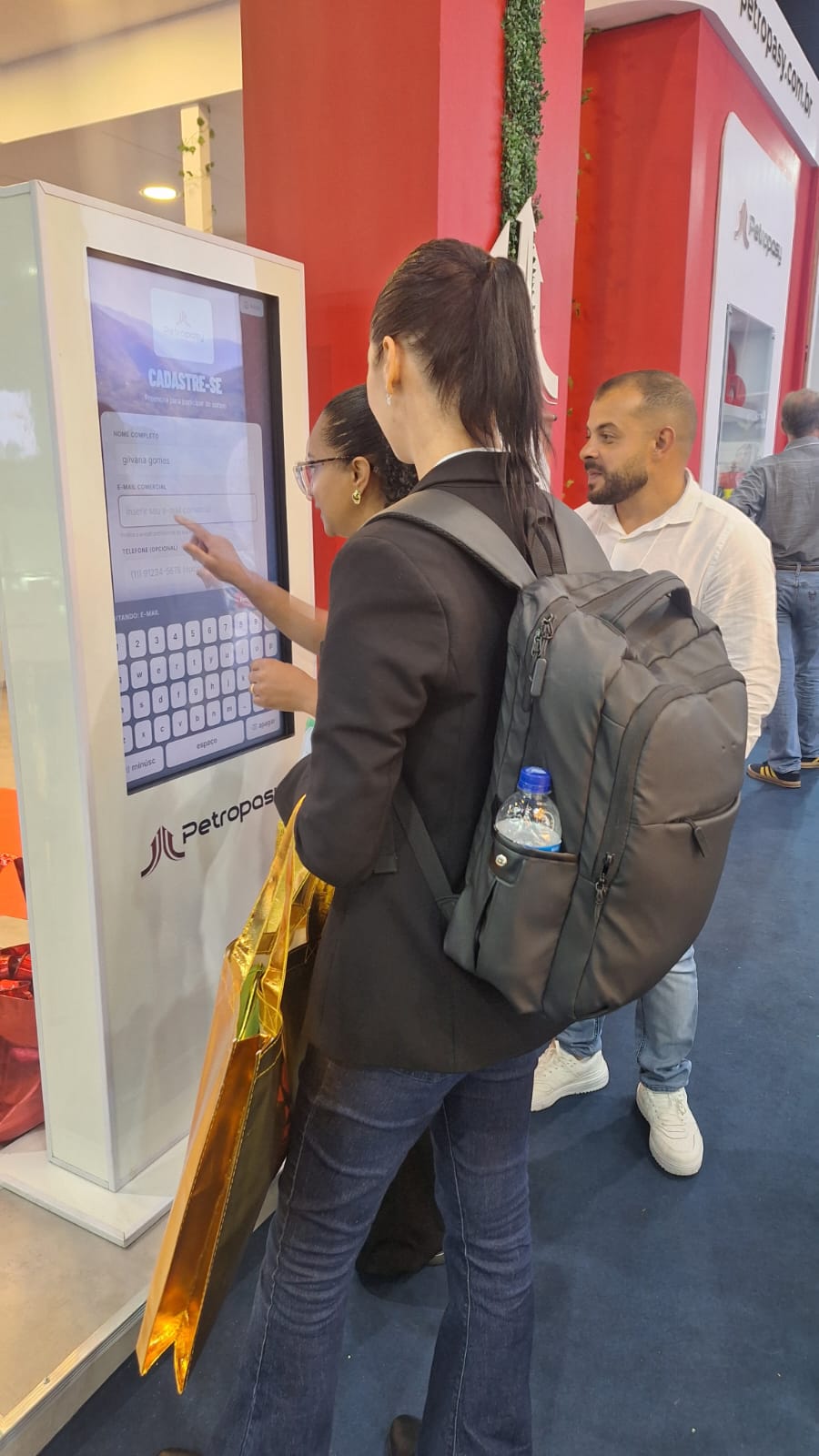 Visitantes fazendo cadastro no totem interativo Totiva+ da Petropasy na Exposibram 2026