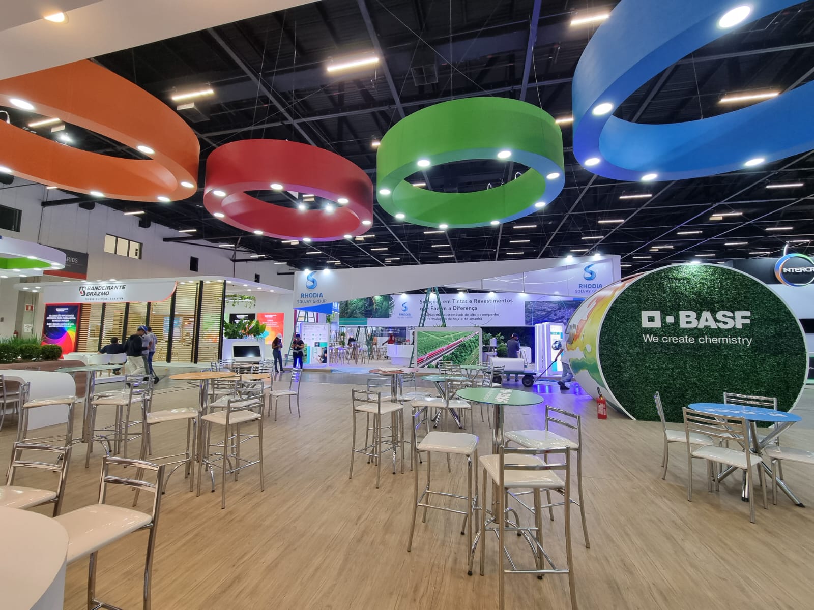 Área de convivência do stand BASF com anéis coloridos suspensos