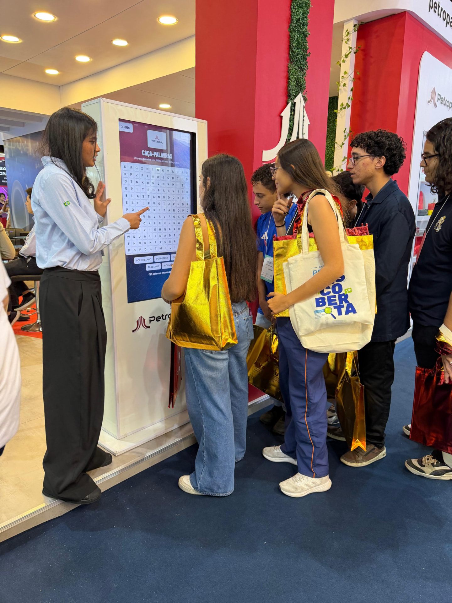 Público jogando o caça-palavras no totem interativo Totivamais no estande da Petropasy na Exposibram 2026