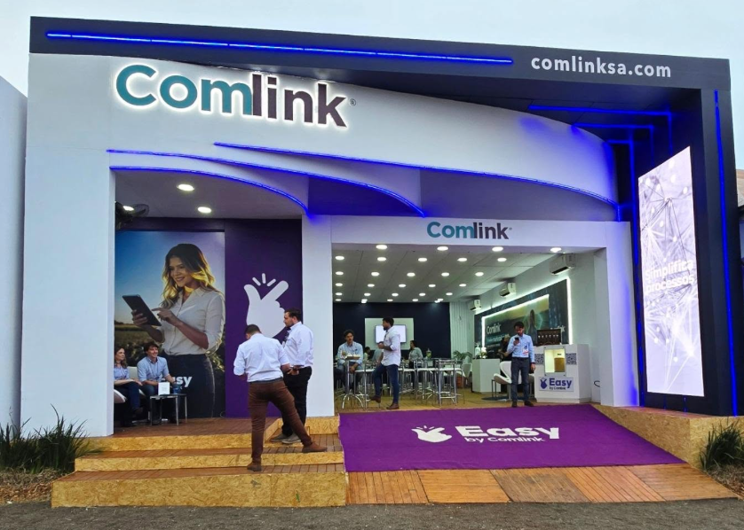 Fachada iluminada do stand Comlink em feira, montagem Map Stands