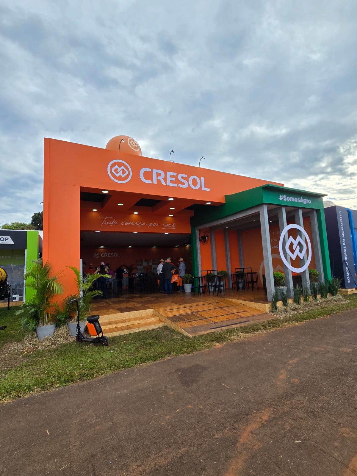 Fachada laranja e verde do stand Cresol com balão da marca