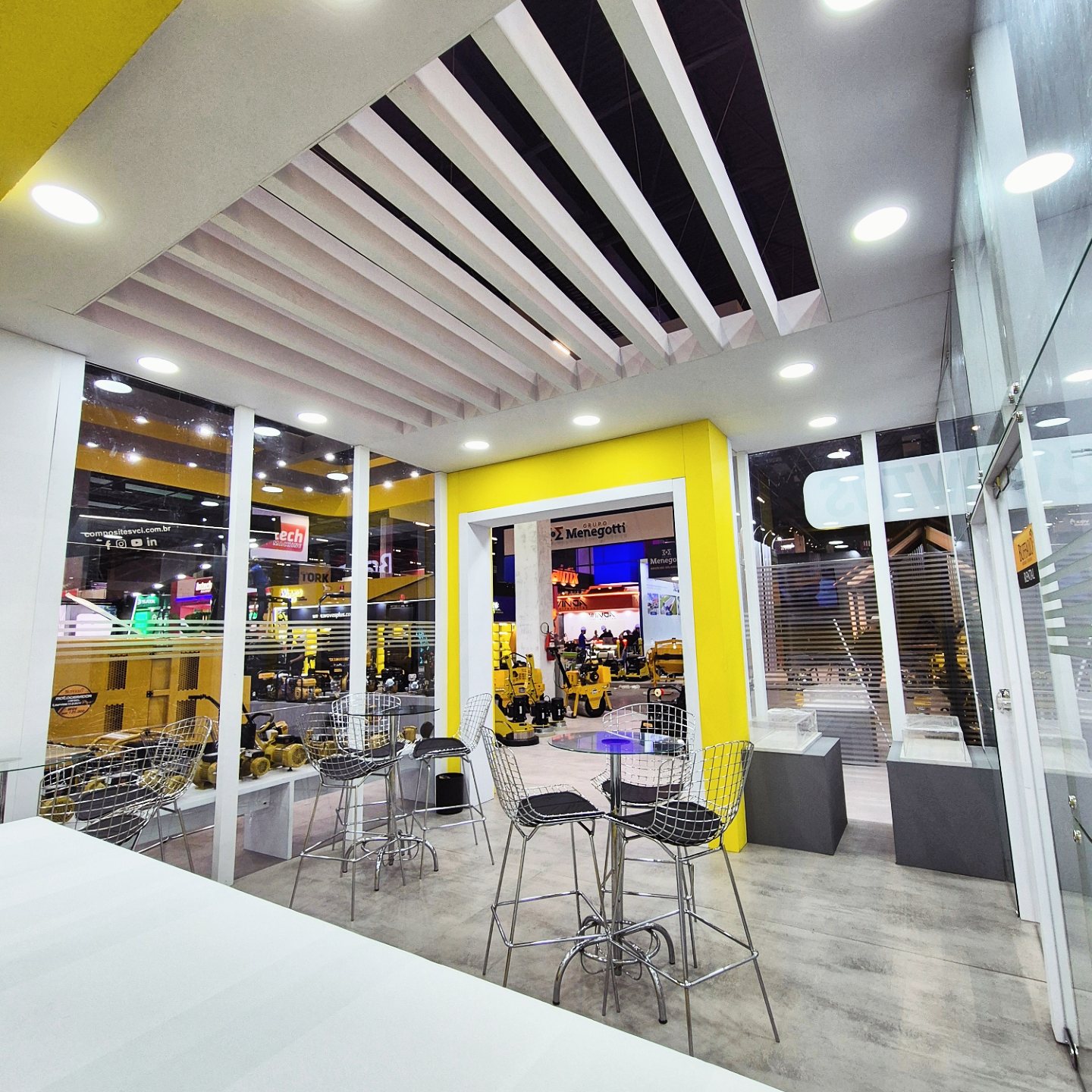 Lounge interno do stand Buffalo Motores com mesas e vitrines
