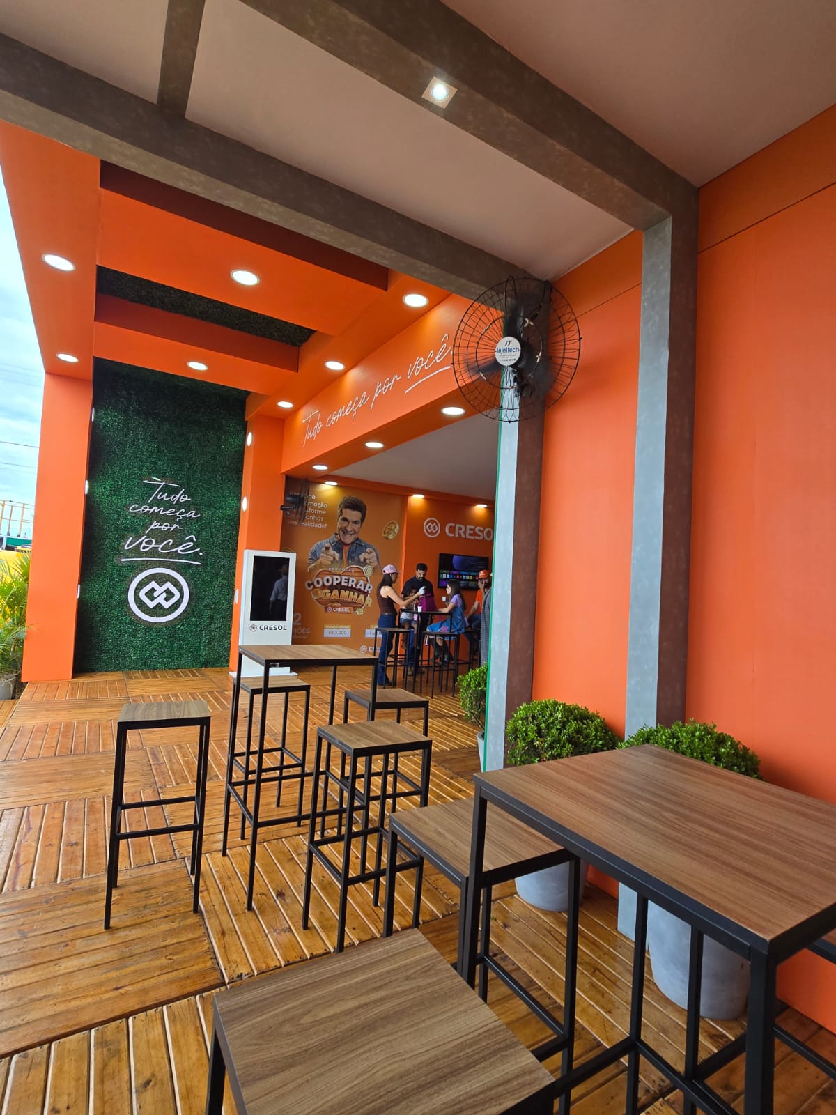 Área de convivência externa do stand Cresol com mesas altas